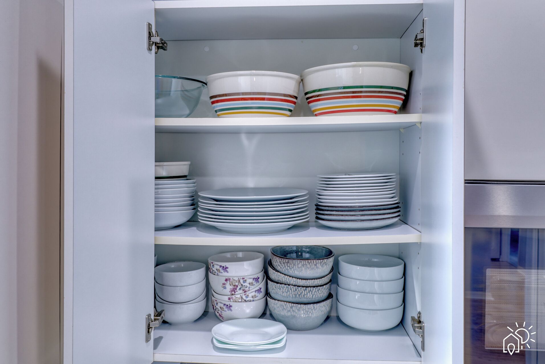 A cabinet with multiple shelves containing various dishes and bowls.