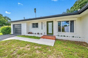 A single-story house with a garage, a front door, and a small porch. - Hot Tub | Private Home | Ping Pong | Mins to Beach (Largo)