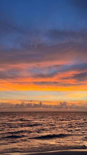 A sunset over a body of water with a distant shoreline. - Hot Tub | Private Home | Ping Pong | Mins to Beach (Largo)