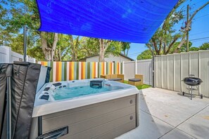 A backyard with a hot tub, a barbecue grill, and a colorful fence. - Hot Tub | Private Home | Ping Pong | Mins to Beach (Largo)