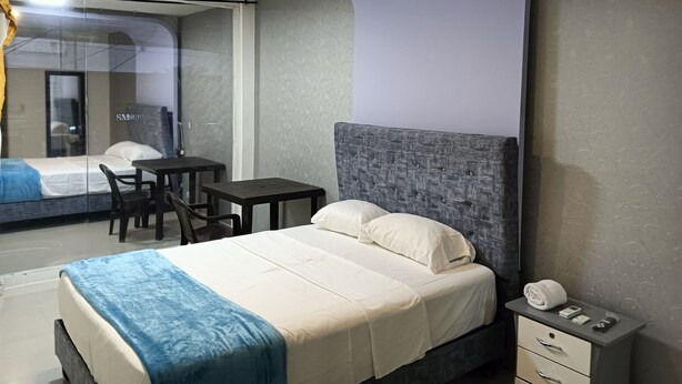 A modern hotel room with a bed, a desk, and a chair. - Hotel Pasarela Cali (Cali)
