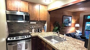 A kitchen with granite countertops, stainless steel appliances, wooden cabinets, and a built-in dishwasher. - Mountain Retreat near mt Baker, cozy 1bedroom Condo w/ Pool, Hot Tub, Crib, wifi (Deming)