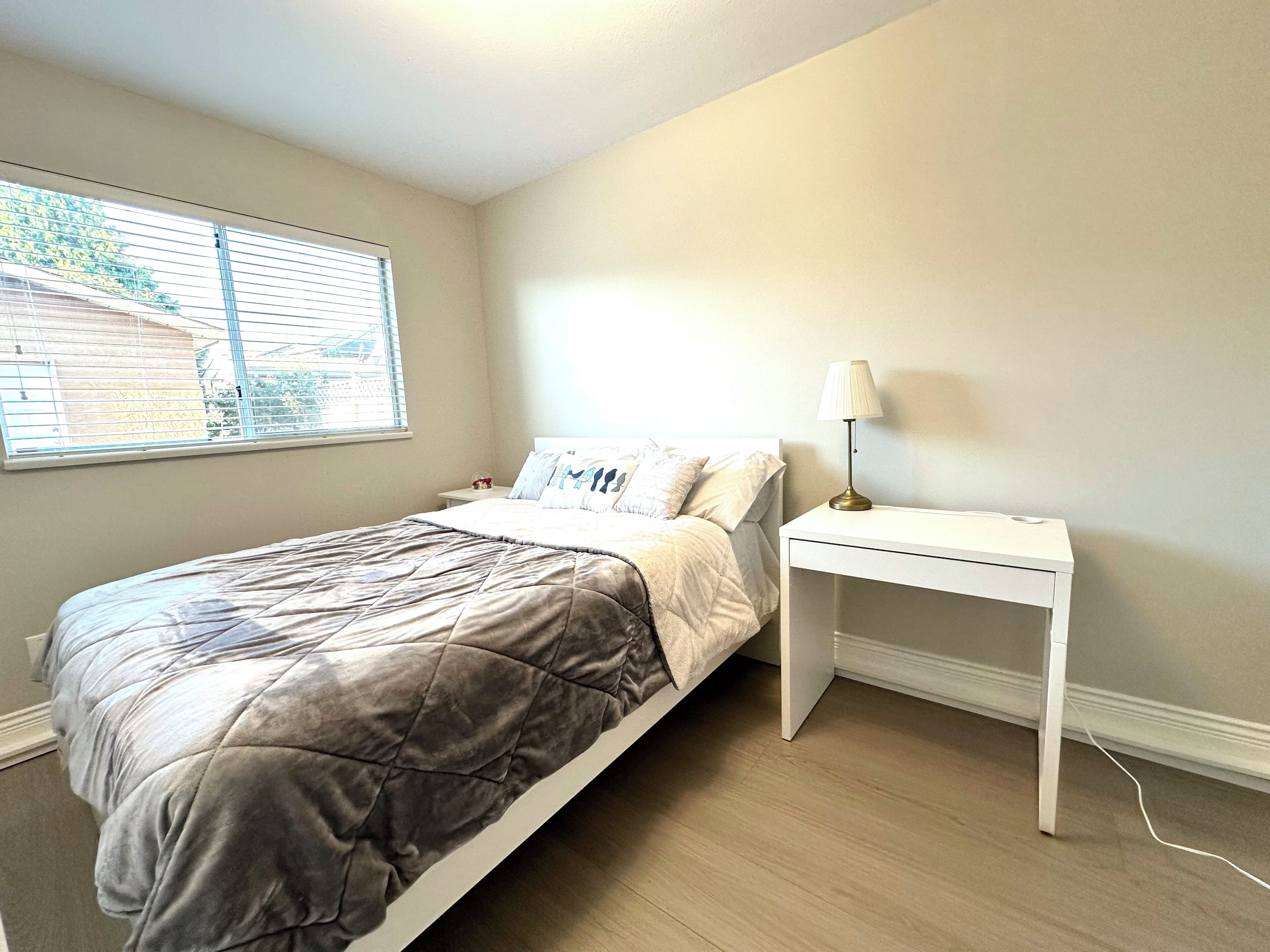 Une chambre à coucher avec un lit, une table de chevet et une lampe.