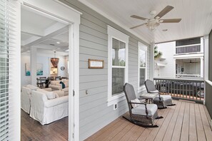 A covered porch with rocking chairs and a dining area. - Time to Wine Down... 6 Bikes and 6-Seater Golf Cart, Heated Resort Pools, Pickleball Courts!!! (Santa Rosa Beach)