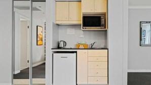 A compact kitchen with a microwave, a small refrigerator, and a sink.
