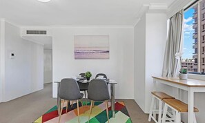 Un espace repas moderne avec une table, des chaises et un tapis aux couleurs vives.