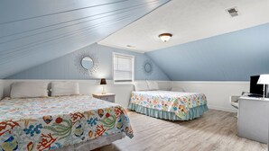 Ein Schlafzimmer mit zwei Betten, einem Schreibtisch und einem Stuhl.