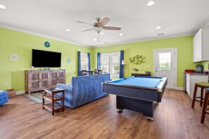 A pool table in a room with green walls, a ceiling fan, and a television on the wall. - Luxury home w/private pool, walking distance to the beach, eateries and shopping (North Myrtle Beach)