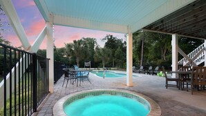 A covered outdoor swimming pool with a patio area, chairs, and a staircase. - Luxury home w/private pool, walking distance to the beach, eateries and shopping (North Myrtle Beach)