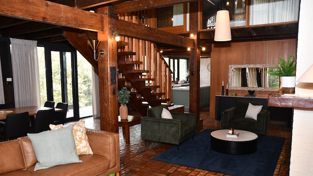 A spacious living area with a wooden staircase, leather sofas, and a dining area with black chairs. - Diskin House Mt Pleasant Rd, Eltham. Great for weddings - 2 Kms to Montsalvat. (Eltham)