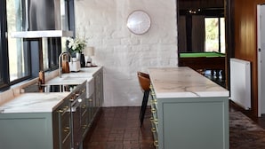 A kitchen with a marble countertop, a clock on the wall, and a view of the outdoors. - Diskin House Mt Pleasant Rd, Eltham. Great for weddings - 2 Kms to Montsalvat. (Eltham)