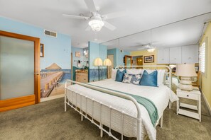 A bedroom with a bed, bedside tables, a ceiling fan, and a mural on the wall. - Oceanfront 2BR/2BA Condo in Oceanside with Amazing Beach Access has AC! (Oceanside)