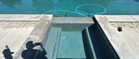Una piscina rectangular amb una zona enrajolada i un desguàs al centre.
