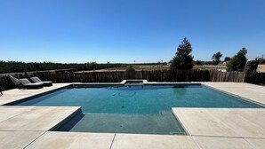 A rectangular swimming pool with a wooden deck and lounge chairs. - Charming cottage with WiFi and AC on a Ranch setting in Oakdale (Oakdale)