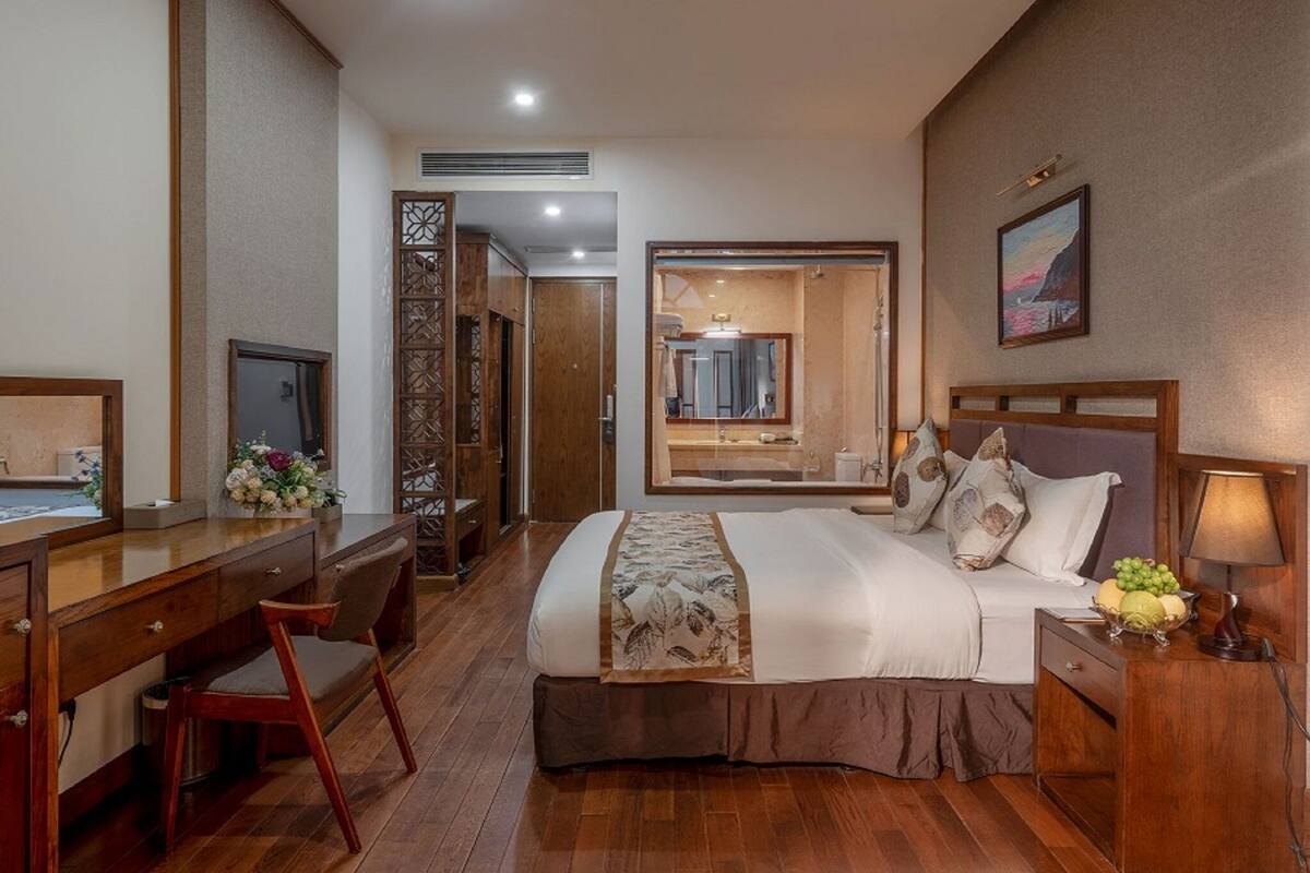 Ein Hotelzimmer mit Bett, Schreibtisch, Stuhl und Spiegel.