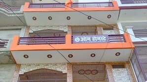 A multi-story building with balconies, a signboard, and barred windows. - Om home stay (Faizabad)