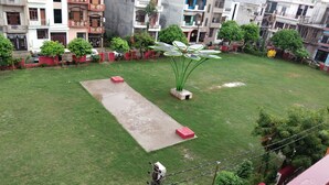 A courtyard with a paved area, potted plants, and a solar panel installation. - Om home stay (Faizabad)