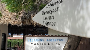A signboard with "Breakfast Lunch Dinner" and "Machele's By Room To Roam" written on it. - Hotel Ingigante Poolside Room (El Gigante)