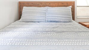 A bed with a wooden headboard and a patterned bedspread.