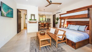 A modern bedroom with a large bed, wooden furniture, and a ceiling fan.