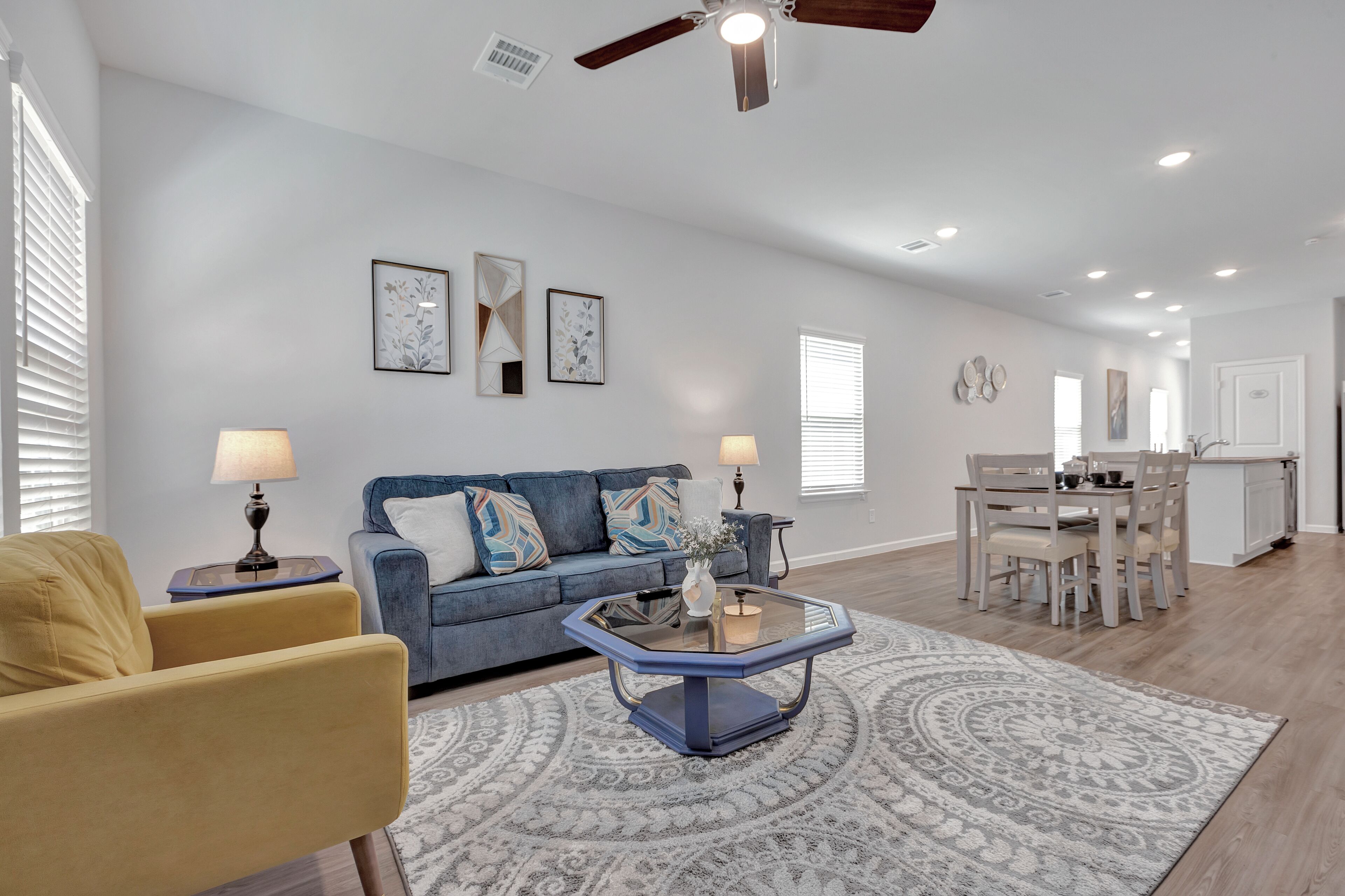 A living room with a sofa, coffee table, and dining area.