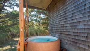 A hot tub in a wooden outdoor area with a wooden deck and a covered section. - Makena's -near beach, game room, hot tub, dog ok (Pacific City)