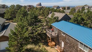 A residential area with houses, a prominent rock formation, and a clear sky. - Makena's -near beach, game room, hot tub, dog ok (Pacific City)