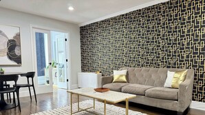 Una sala moderna con un sofá modular, una mesa de centro y una pared con diseño.