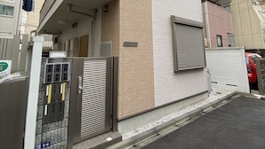 A modern two-story house with a balcony, a gated entrance, and a small driveway. - Gracious Higashi Shinjuku (Tokyo)