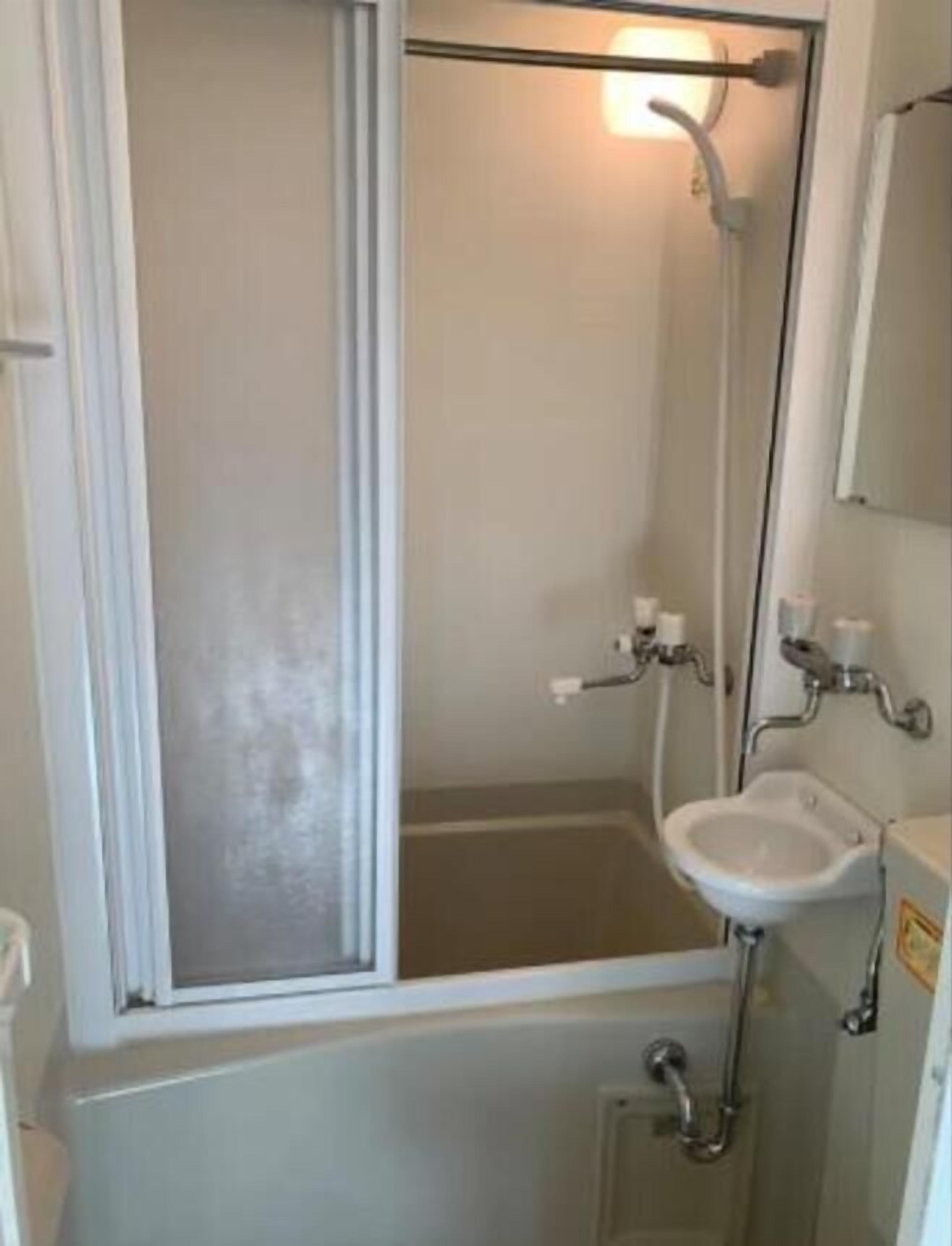 Un bagno piccolo e intimo con finestra, lavandino e doccia.