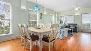 Un espace repas comprenant une table et des chaises, un lustre et un ventilateur de plafond.
