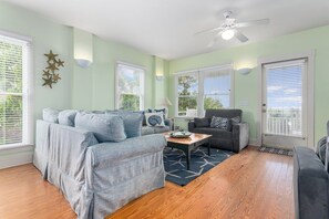 A living room with a sectional sofa, a coffee table, and a gray armchair.