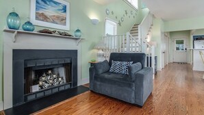 Un salon avec une cheminée, un canapé et un escalier menant à une autre pièce.