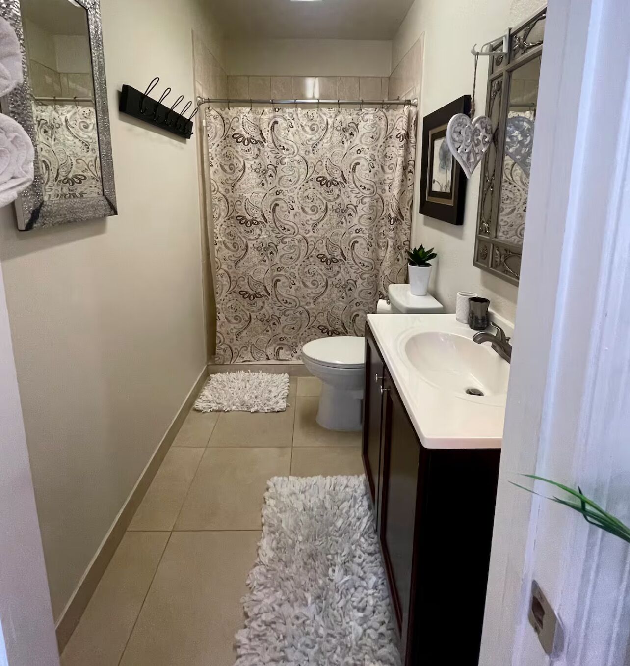 Een badkamer met toilet, wastafel en douchegordijn.