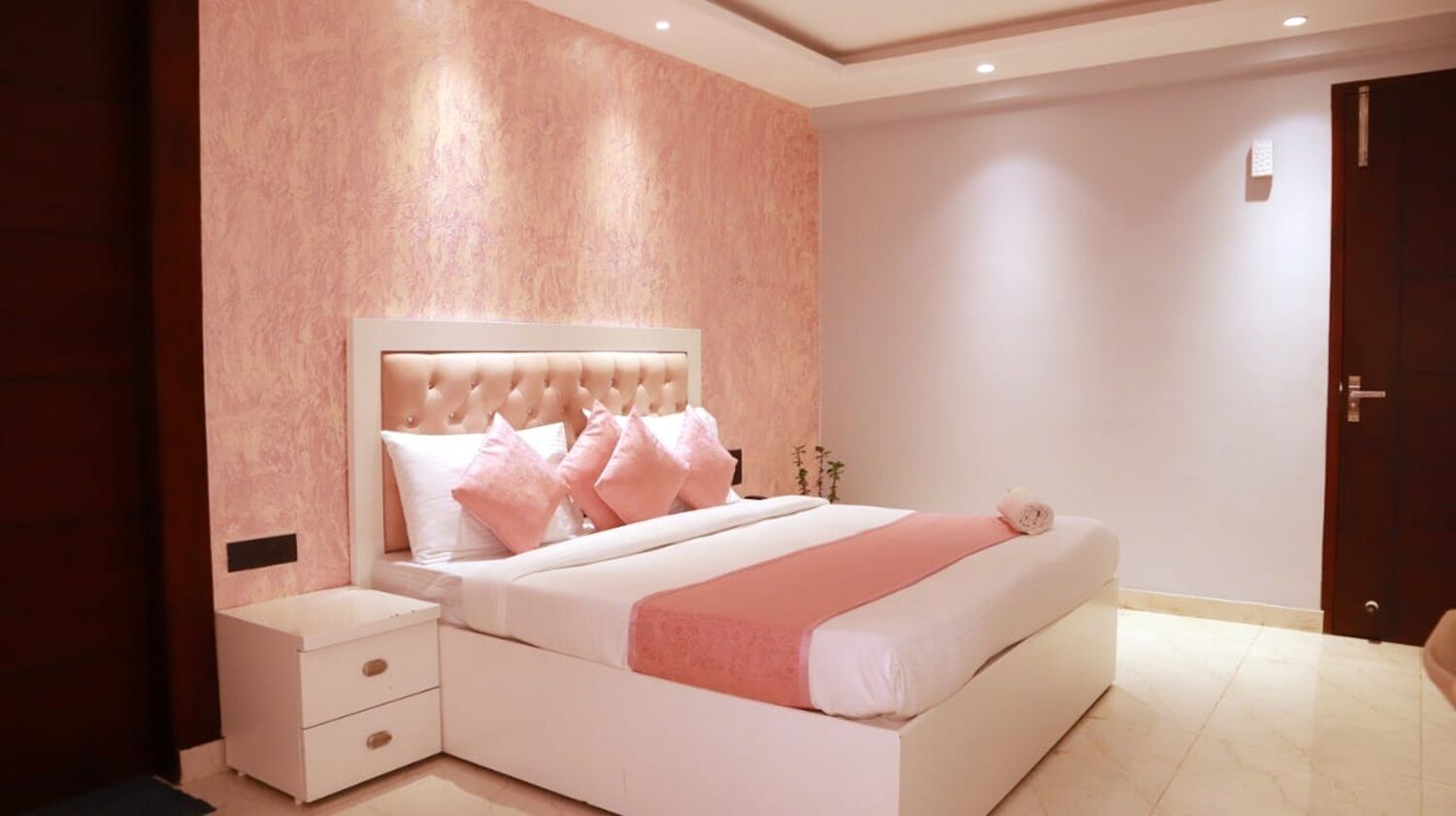 Ein Schlafzimmer mit einem großen Bett, einem Nachttisch und einer Tür.