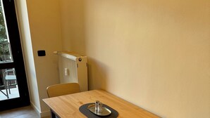 A dining table with a chair, a radiator, and a window. - Cool Vitkova apartment near Florenc with small balcony (Hlavní mesto Praha)