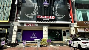 Un hotel amb un cartell ben visible per a 'Arabian Hotel' i un número de contacte.