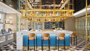 A bar area with a marble countertop, multiple liquor bottles, and bar stools. - Echarm plus International Hotel Guangzhou Changgang Subway Station - Free Shuttle Bus to Canton Fair Complex During Canton Fair Period (Guangzhou)