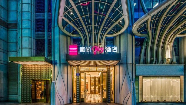 A hotel entrance with a modern design, featuring a prominent sign and a checkered floor pattern leading inside. - Echarm plus International Hotel Guangzhou Changgang Subway Station - Free Shuttle Bus to Canton Fair Complex During Canton Fair Period (Guangzhou)