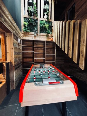 Relax and play in this cozy space with a foosball table and shelving units.