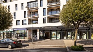 A modern building with a storefront named "Le Salon de Lucile" featuring a salon and a café. - Nautica by Interhome (Saint Malo)