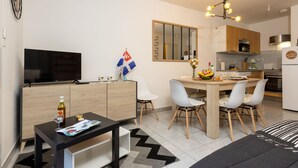 A modern apartment with a living area, dining space, and kitchen. - Nautica by Interhome (Saint Malo)
