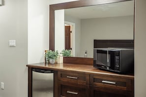 A kitchen with a microwave, wooden countertop, and a dishwasher.