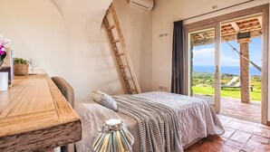 A bedroom with a bed, a wooden desk, a ladder, and a view of the outdoors. - Stazzo Serafini by Interhome (Rena Majore)