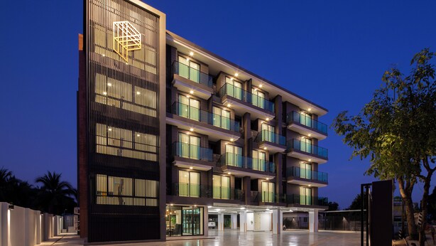 Un hotel de varios pisos con diseño moderno, con balcones y grandes ventanales.