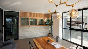 Un interior moderno con una mesa de comedor de madera, una planta en maceta y un candelabro único.