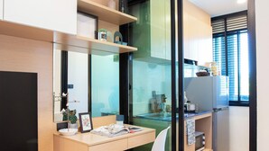 Una cocina moderna con estufa integrada, refrigerador y ventana con persianas.