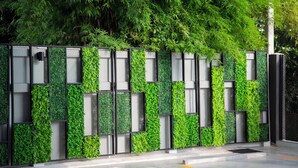 Fachada moderna de edificio con jardín vertical verde.