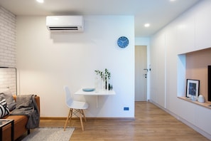 Departamento Deluxe, balcón, vista a la ciudad | Área de sala de estar | Televisión de pantalla plana de 50 pulgadas con canales digitales 