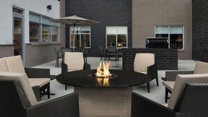 A patio area with a round table, chairs, and a fire feature. - Residence INN BY Marriott Dayton Miamisb (Miamisburg)